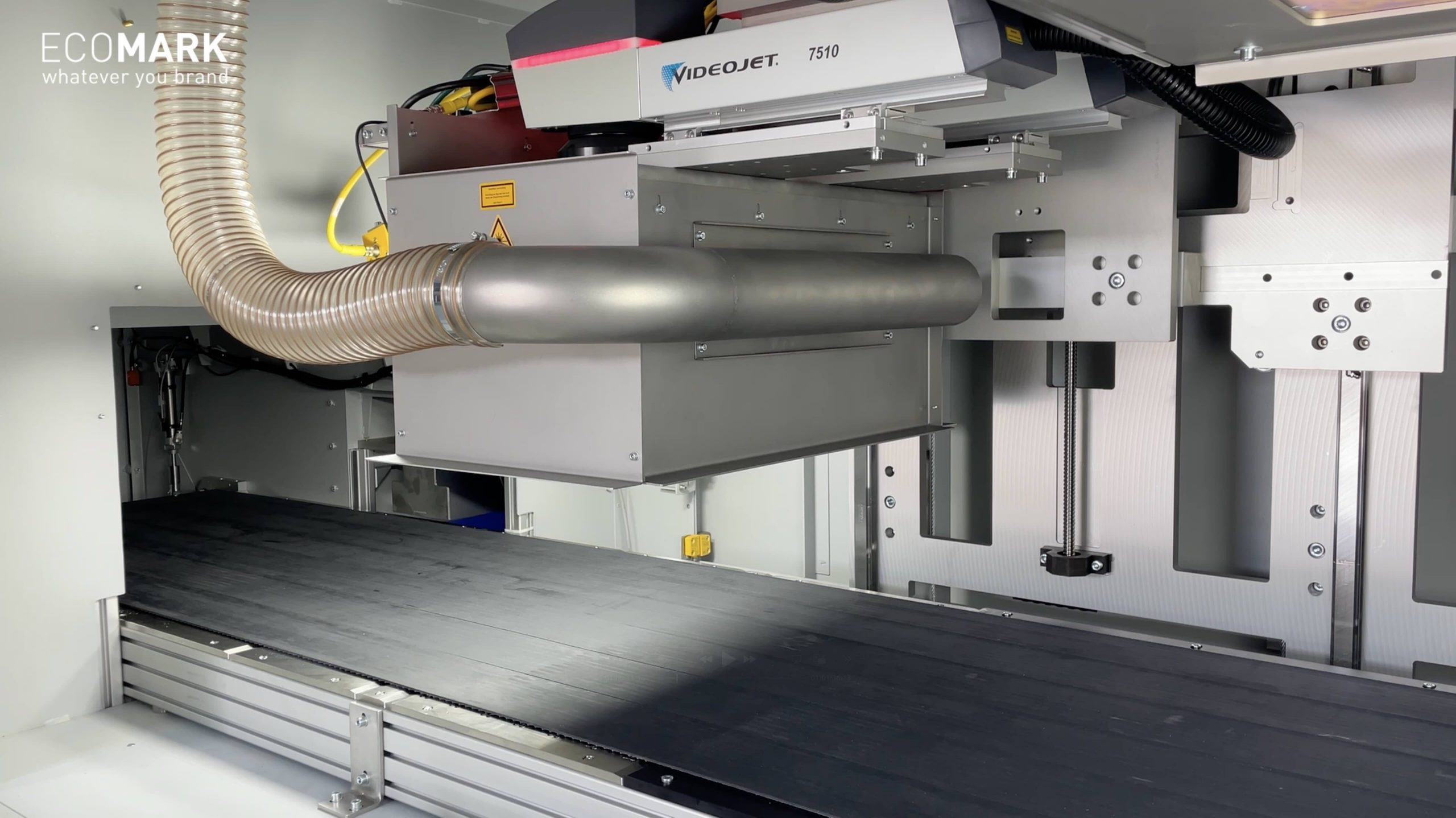 Nahaufnahme eines Industriedruckers mit Förderband, metallischen Komponenten und etikettierten Geräten, darunter ein Videojet 7510, in einer sauberen, gut beleuchteten Einrichtung. eco-mark ecomark laserkennzeichnung laserbeschriftung industrie